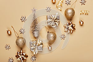 Golden christmas decor and bauble on beige background. Creative layout in neutral monochrome colors