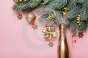 Golden christmas decor and bauble on pink background. Creative layout made of spruce branches and golden decorations