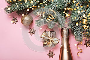 Golden christmas decor and bauble on pink background. Creative layout made of spruce branches and golden ornaments