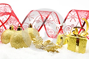 Golden christmas gifts,baubles red ribbon on snow