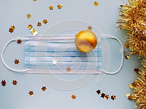 Golden Christmas tree ball and face mask on a blue background  for Christmas