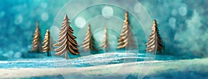 Golden Christmas Trees in a Mystical Winter snowy Landscape. Panorama with copy space, minimalistic background.