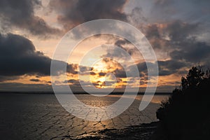 A golden cloudy sunset over the rippling water in Pegwell Bay, Ramsgate