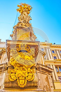 The golden Coat of Arms on the basement of Plague Column in Vienna, Austria