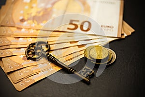 Golden coins with key, key to money, om dark background