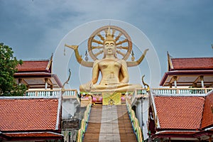 Golden color buddha statue in the buddhist temple. Thailand. Cloudy day