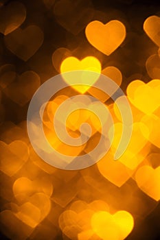 Golden color heart bokeh background photo. Abstract holiday, celebration backdrop.