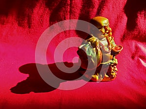 Golden color laughing Buddha in crimson red background