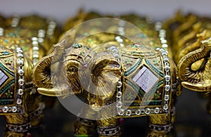 Golden colored elephant figures with trunk up