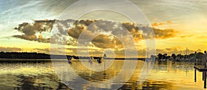 Golden coloured cumulus cloud, coastal sunset seascape.