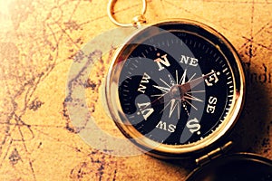 Golden compass on old treasure map