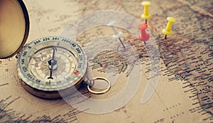 The golden compass is placed on the world map.