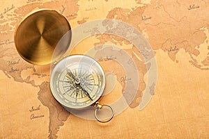 Golden compass on vintage world map. Travel planning concept