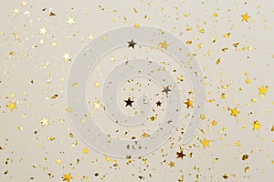 Golden confetti on beige paper background. Festive holiday backdrop. Birthday congratulations Christmas New Year.