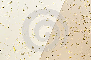 Golden confetti on beige  white paper geometric trendy background. Festive holiday backdrop. Birthday congratulations Christmas