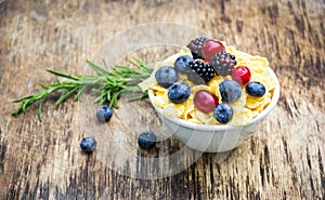 Golden corn flakes and fresh berries. Cranberries, blueberries and blackberries. Useful breakfast