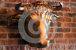 The golden cow head in the red bricks wall