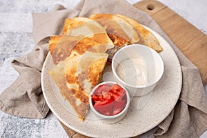 Golden and crispy chicken and cheese quesadilla with sides