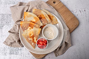 Golden and crispy chicken and cheese quesadilla with sides