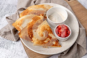 Golden and crispy chicken and cheese quesadilla with sides