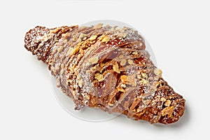 Golden croissant with chocolate icing and caramelized crumbles