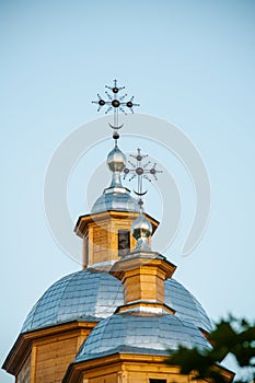 Golden cross and the dome of the old wooden Orthodox church against the blue sky. Close-up