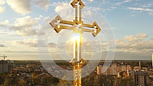 Golden cross of orthodox church with glitter on sky background