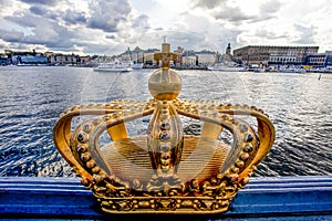 Golden crown on Skeppsholm bridge with Stockholms slot royal palace in the background - Stockholm - Sweden