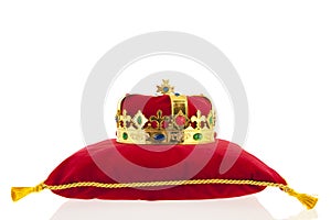 Golden crown on velvet pillow