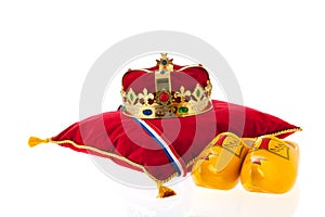 Golden crown on velvet pillow with wooden shoes