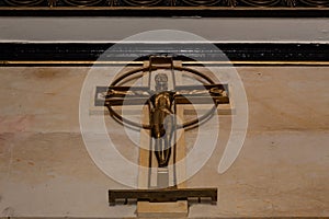 Golden crucified jesus christ figure inside a mausoleum cemetery
