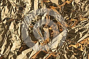 Golden crumpled shiny metallic paper. Yellow tinfoil texture for holiday. Glossy crinkled kitchen foil background