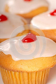 Golden cupcakes with lemon frosting and cherry