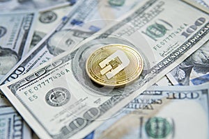 Golden Dash Cryptocurrency coin on a pile of US dollars, cash money and crypto currency concept. Virtual. Metal coins of