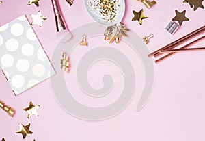 Golden decor and feminine accessories on the pink background,