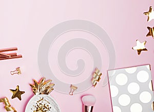 Golden decor and feminine accessories on the pink background,