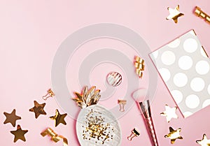 Golden decor and feminine accessories on the pink background,