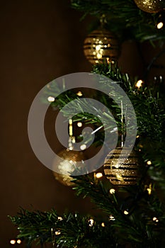 A golden decorative ball suspended on a Christmas tree