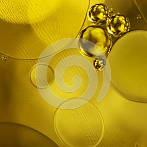 Golden decorative bubbles and circles of oil on the surface of the water