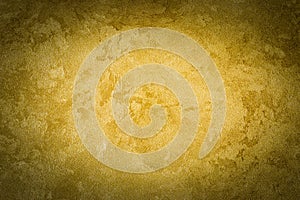 Golden decorative plaster texture with vignette. Abstract grunge background with copy space
