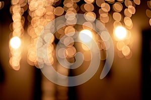 Golden defocused bokeh lights on an isolated black background. Abstract magic background with bokeh effect, golden