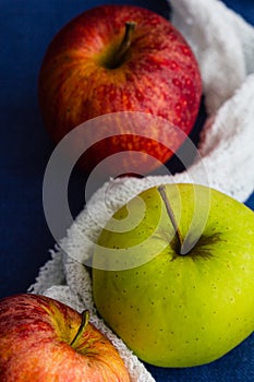 Golden delicious and royal gala apples with a white cloth against a blue background. Close up, selective focus