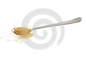 Golden demerara sugar spilled from teaspoon