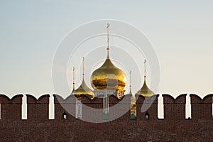 Golden domes of Assumption Cathedral behind the kremlin wall merlons