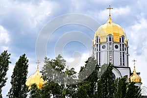 The golden domes of the church and the cloud blue sky on a warm Easter day