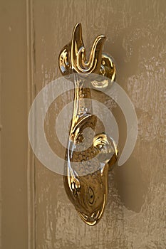 Golden door handle in the form of fairy fish