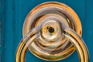 Golden door knocker on a blue wooden door