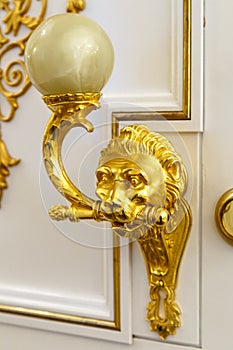 Golden door knocker in the shape of lion on a wooden door
