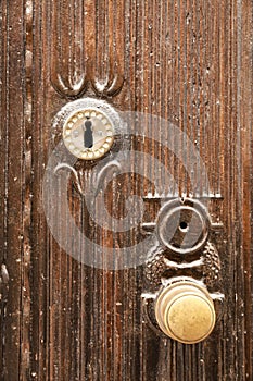 Golden doorknocker with modernist style on old wooden door