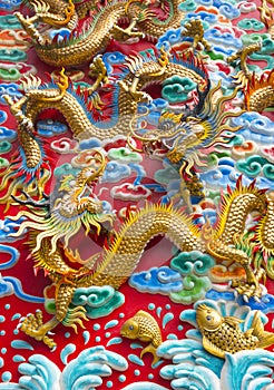 The golden dragon statue on wall at chinese temple